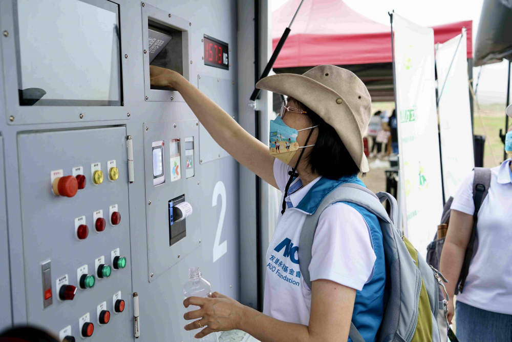 志工們將拾起的寶特瓶投入「好歸塑專車」，讓廢棄塑料空瓶可以直接粉碎、縮小體積，未來將可再製成購物袋、寶特衣、悠遊卡等生活用品